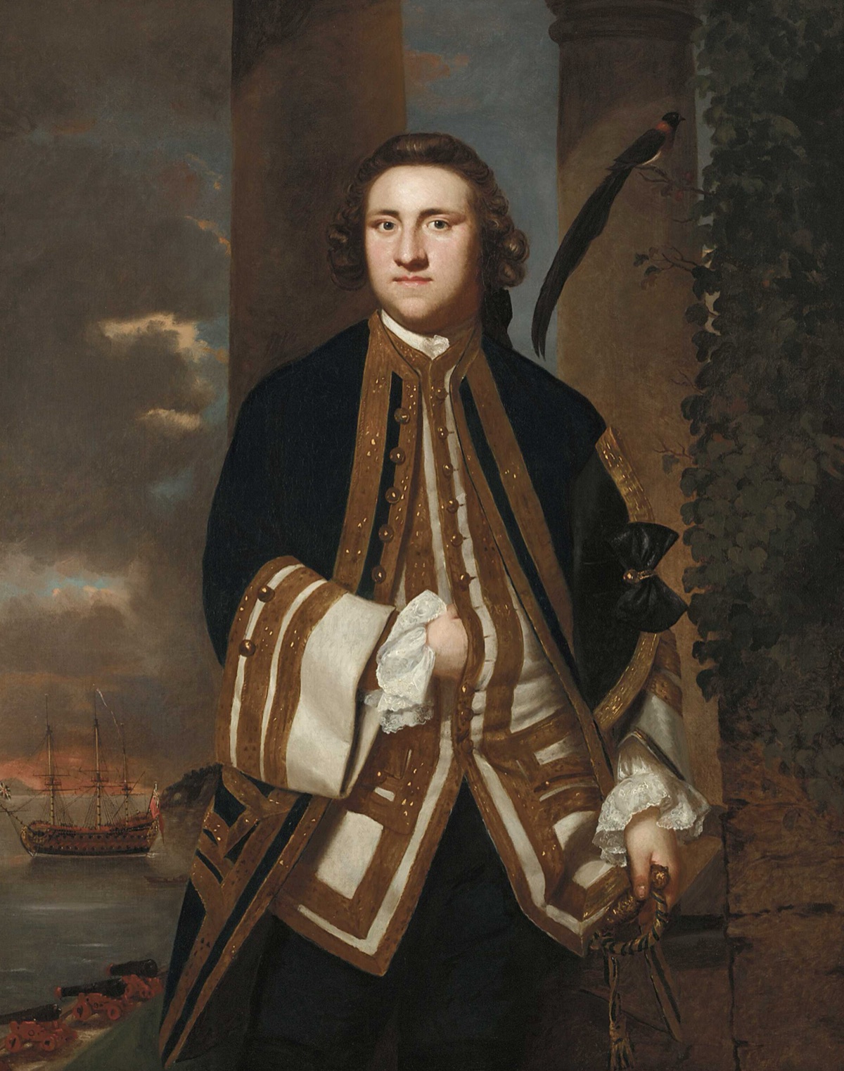 A three-quarter-length portrait of a young naval captain in a blue coat with gold lace, a long-tailed bird on a branch behind him and a two-decked warship at anchor in the distance